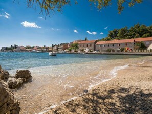 A coastal town with stone buildings, a clear blue sea, and rocky shoreline. - Fancy Apartments Dream - Comfort One Bedroom Apartment With Balcony and Sea View (Smokvica)