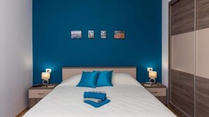 Ein Schlafzimmer mit einem großen Bett, blauen Wänden und einem Holzschrank.
