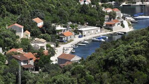 Ein Küstendorf mit Steinhäusern, einem Yachthafen und Booten.