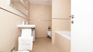 A bathroom with a bathtub, a sink, and a toilet. - Apartment Vesna - Superior Three Bedroom Apartment With Balcony (Dubrovnik)