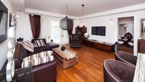 A modern living room with a sofa set, a coffee table, and a television. - Apartment Vesna - Superior Three Bedroom Apartment With Balcony (Dubrovnik)