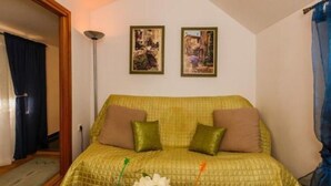 A room with a bed, two framed pictures on the wall, a floor lamp, and a window with curtains. - Apartments Roda - One Bedroom Apartment With Terrace - (Supetar)