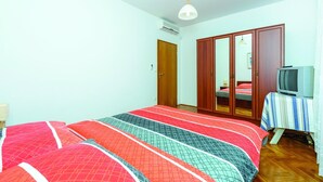 A bedroom with a bed, wardrobe, and television.
