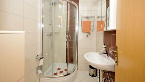 A bathroom with a glass-enclosed shower, a white sink, and a mirror above the sink. - Apartments Villa Moonlight - One Bedroom Apartment With Sea View Balcony (Okrug)