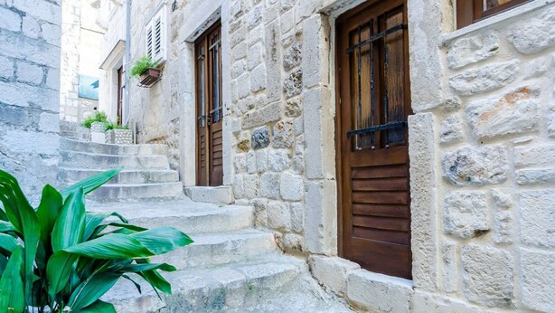 A stone building with a staircase leading to a wooden door. - Holiday Home St George - Two Bedroom Apartment With City View (Dubrovnik)