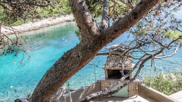 A stone-built outdoor area with a clear blue pool, a stone oven, and a view of the surrounding landscape. - Seafront Apartments Olivera-one Bedroom Apartment With Balcony and Sea View (Blato)