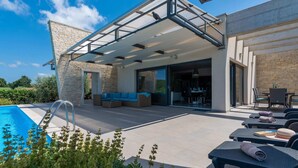 A modern outdoor living area with a pool, seating, and a covered patio. - Modern Villa With Pool, Covered Terrace and sea View (Novigrad)