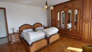 Une chambre à coucher avec un lit double, une armoire en bois et un lustre.