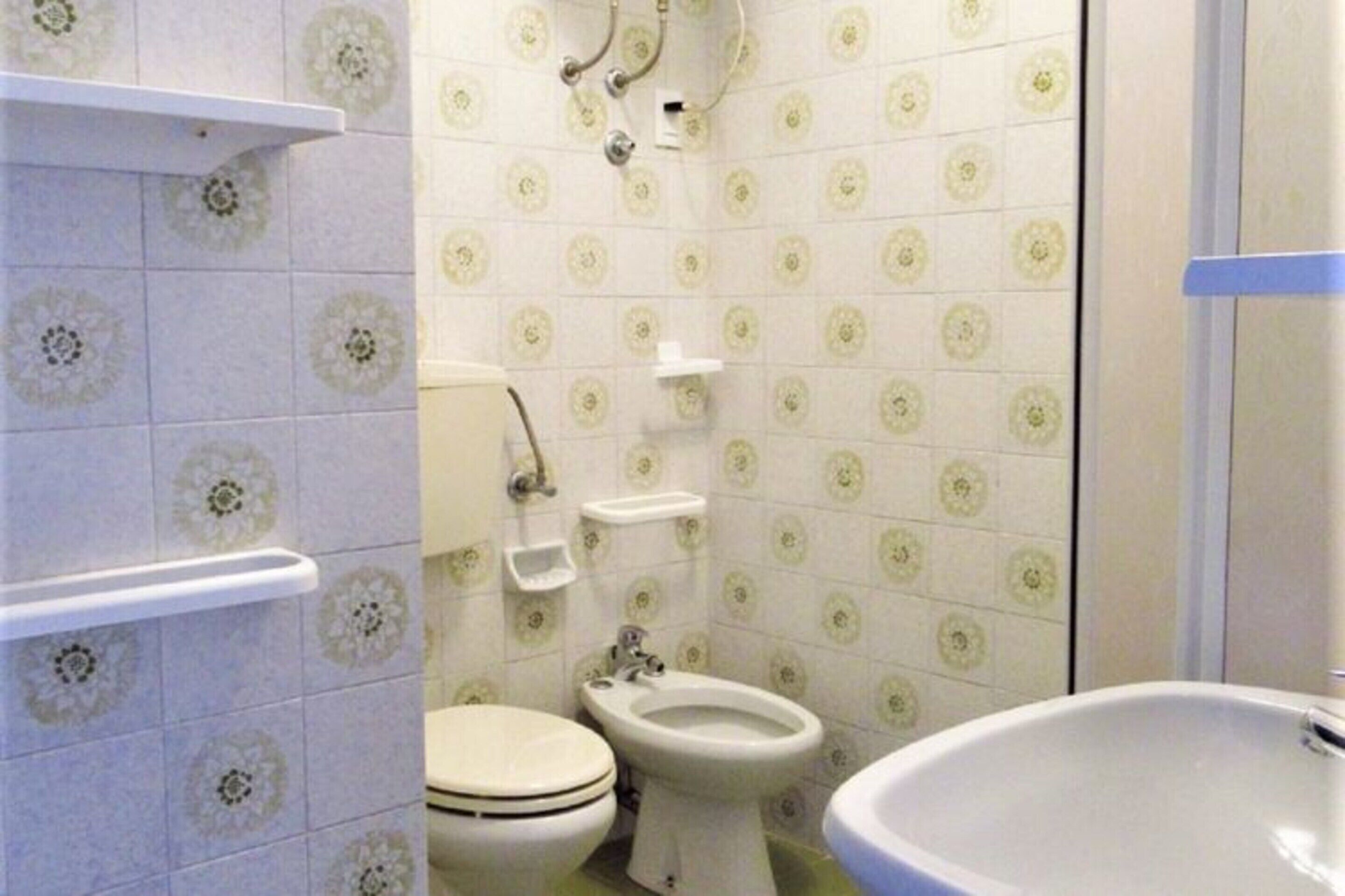 A bathroom with a toilet, bidet, and sink.