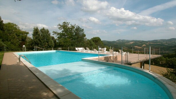 A swimming pool with a view of hills and trees. - Holiday Home in Citerna Near Castello Bufalini (Citerna)