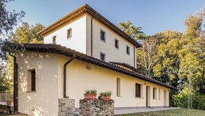 A two-story building with a light-colored facade, stone pillars, and potted plants. - Holiday Home in Citerna Near Castello Bufalini (Citerna)