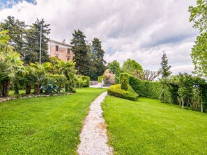 A well-maintained garden with a gravel path leading to a building. - Belvilla by OYO Rose di Fratta 2 (Cupramontana)