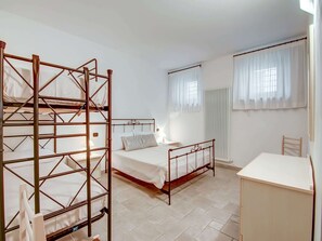 A room with bunk beds, a single bed, a desk, and a radiator. - Belvilla by OYO Rose di Fratta 2 (Cupramontana)