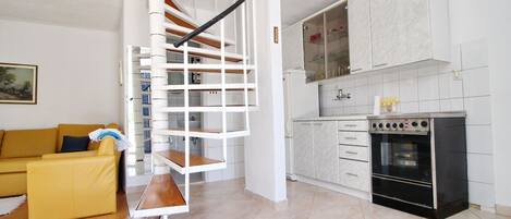 A modern kitchen with white cabinets and a built-in oven.