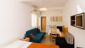 A compact room with a bed, a sofa, a dining table, and a kitchenette. - Apartments Felix Mljet - One Bedroom Apartment With Balcony (Mljet)