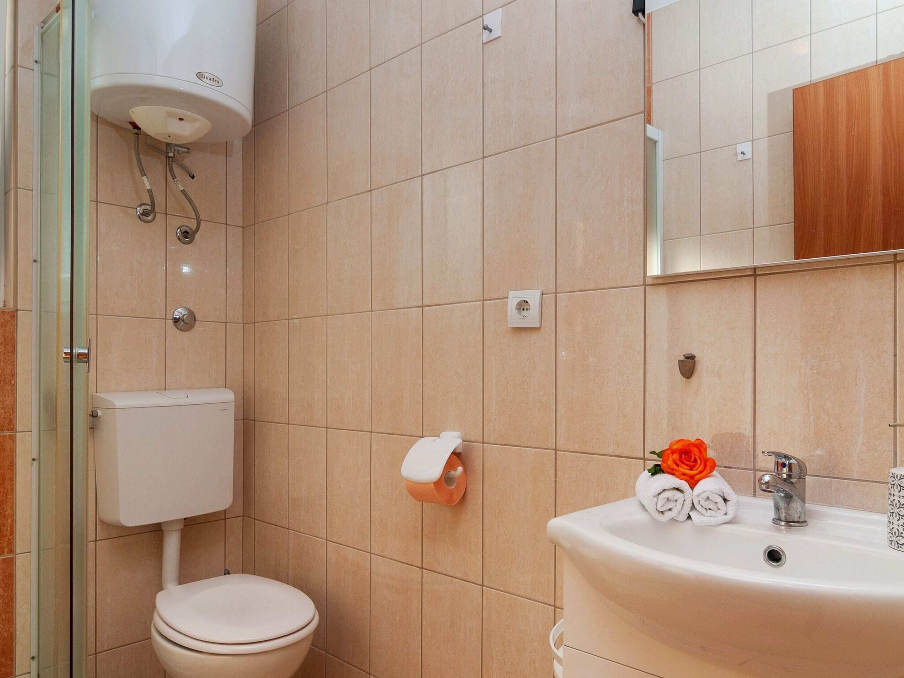 Un baño con inodoro, lavabo y espejo.