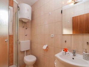 Un baño con inodoro, ducha y lavamanos.