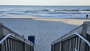 A wooden staircase leading to a sandy beach with a view of the ocean. - Oceanfront Winter Escape- Ask About Monthly Discounts – Heated Pools/Spas/Views (Myrtle Beach)