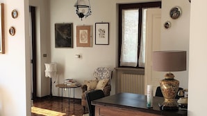A cozy room with a wooden dining table, a patterned armchair, and a lamp. - Vesime Villa With Garden (Vesime)