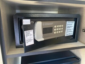 A safe deposit box with a keypad, a lock, and instructions in multiple languages.