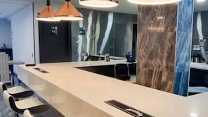 Une cuisine moderne dotée d’un long comptoir, de tabourets de bar et de luminaires suspendus.
