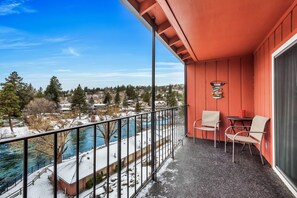 A balcony with a view of a river and snow-covered landscape.
