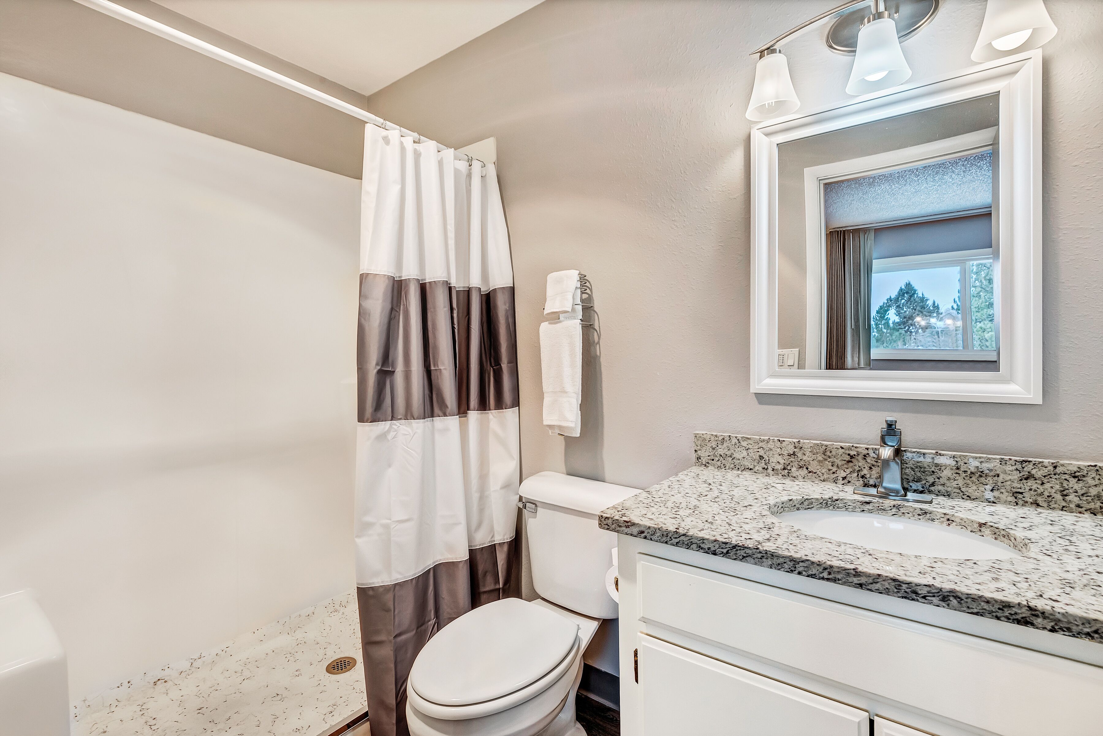 A bathroom with a toilet, sink, and shower curtain.