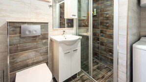 A modern bathroom with a glass shower enclosure, a white sink, and a toilet. - Apartments Lucija - One Bedroom Apartment With Terrace (Dubrovnik)