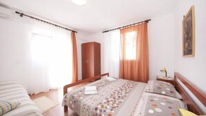 Una camera da letto ben illuminata con un letto, un armadio e un comodino.