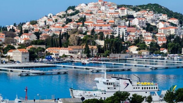 A coastal town with a marina, boats, and buildings with red roofs. - Apartment Radovan - One-bedroom Apartment With Balcony and Sea View (Dubrovnik)