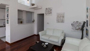 A modern living room with a white sofa, a coffee table, and artwork on the walls. - Apartment Super Marijo - Two-bedroom Apartment With Sea View (Dubrovnik)