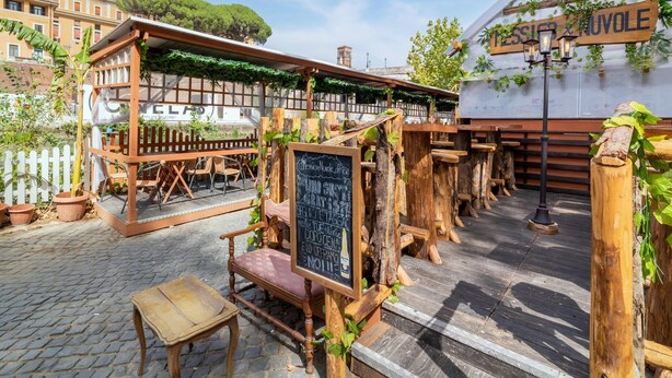 An outdoor seating area with wooden tables and chairs, a chalkboard menu, and a sign reading "Messina Nuvole". - Apartment in Rome With Balcony (Rome)