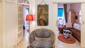 A living room with a zebra-patterned chair, a red lamp, and a painting on the wall. - Apartment in Rome With Balcony (Rome)