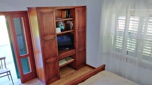 A bedroom with a wooden wardrobe, a bed, and a window with blinds. - Guest House Hazdovac Rooms - Two Bedroom Apartment With Terrace and Sea View (Mljet)