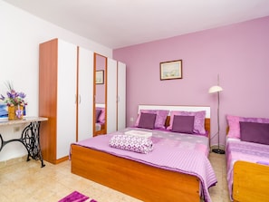A bedroom with a wooden bed, two bedside tables, a wardrobe, and a desk with a vase of flowers. - Apartment Bay Of Dreams - Two-bedroom Apartment With Terrace and Sea View (Janjina)