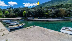 A marina with several boats docked, a clear blue sky, and a mountainous backdrop. - Apartment Bay Of Dreams - Two-bedroom Apartment With Terrace and Sea View (Janjina)