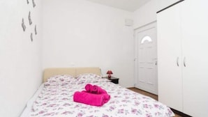 A bedroom with a bed, a nightstand, a wardrobe, and a door. - Apartments Dalamar - Studio With Terrace (Mljet)