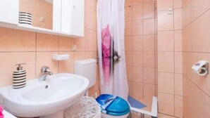 A bathroom with a white sink, a toilet, and a shower area with a white curtain. - Apartments Dalamar - Three-bedroom Apartment With Terrace (Mljet)