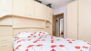 A bedroom with a bed, a wardrobe, and a door leading to another room. - Apartments Dalamar - Three-bedroom Apartment With Terrace (Mljet)