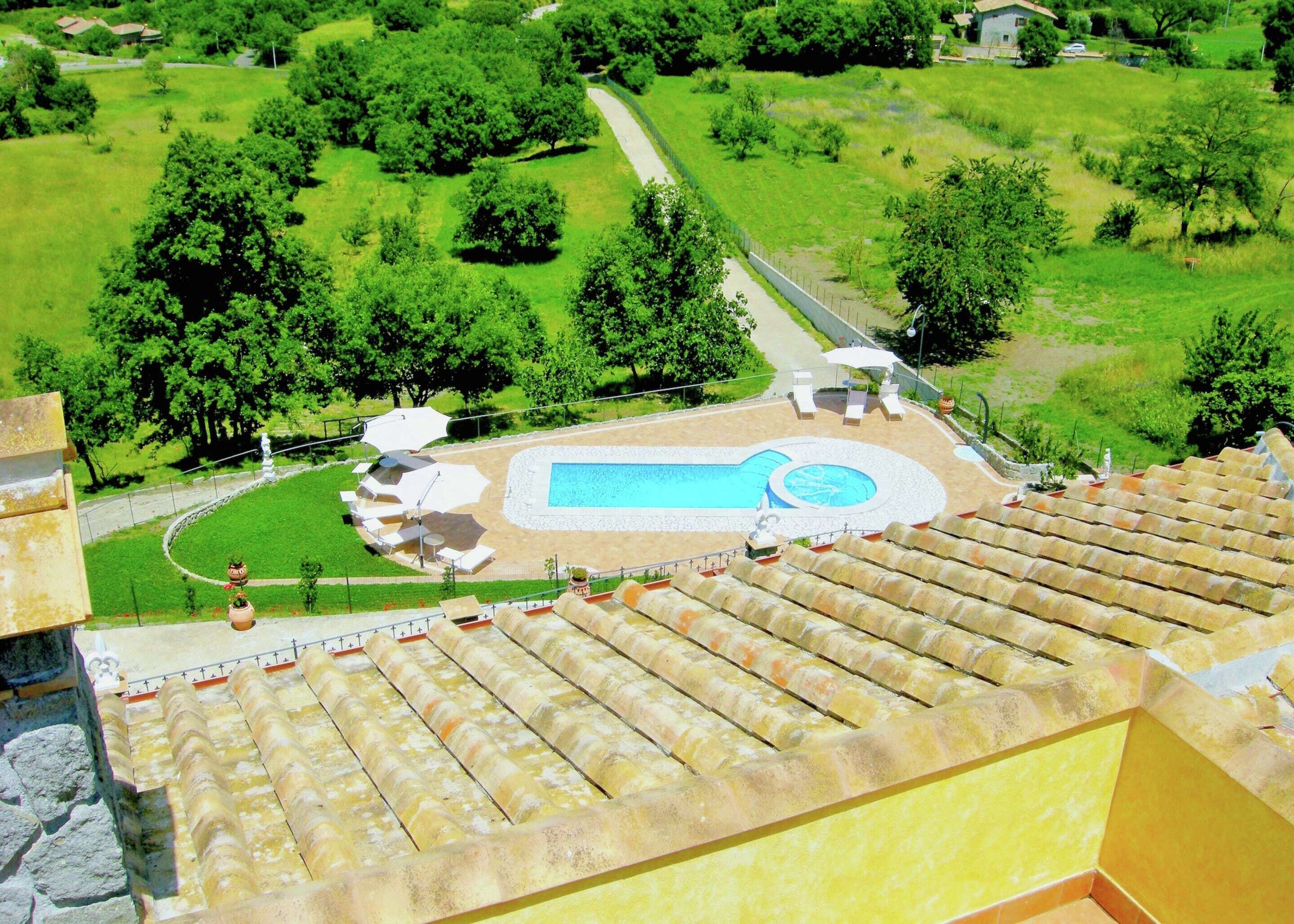 A rooftop pool with a circular design, surrounded by lounge chairs and umbrellas.