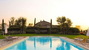 A rectangular swimming pool with a stone border, surrounded by a well-maintained lawn and trees. - Belvilla by OYO Vocabolo Ronda3 12 p (Parrano)