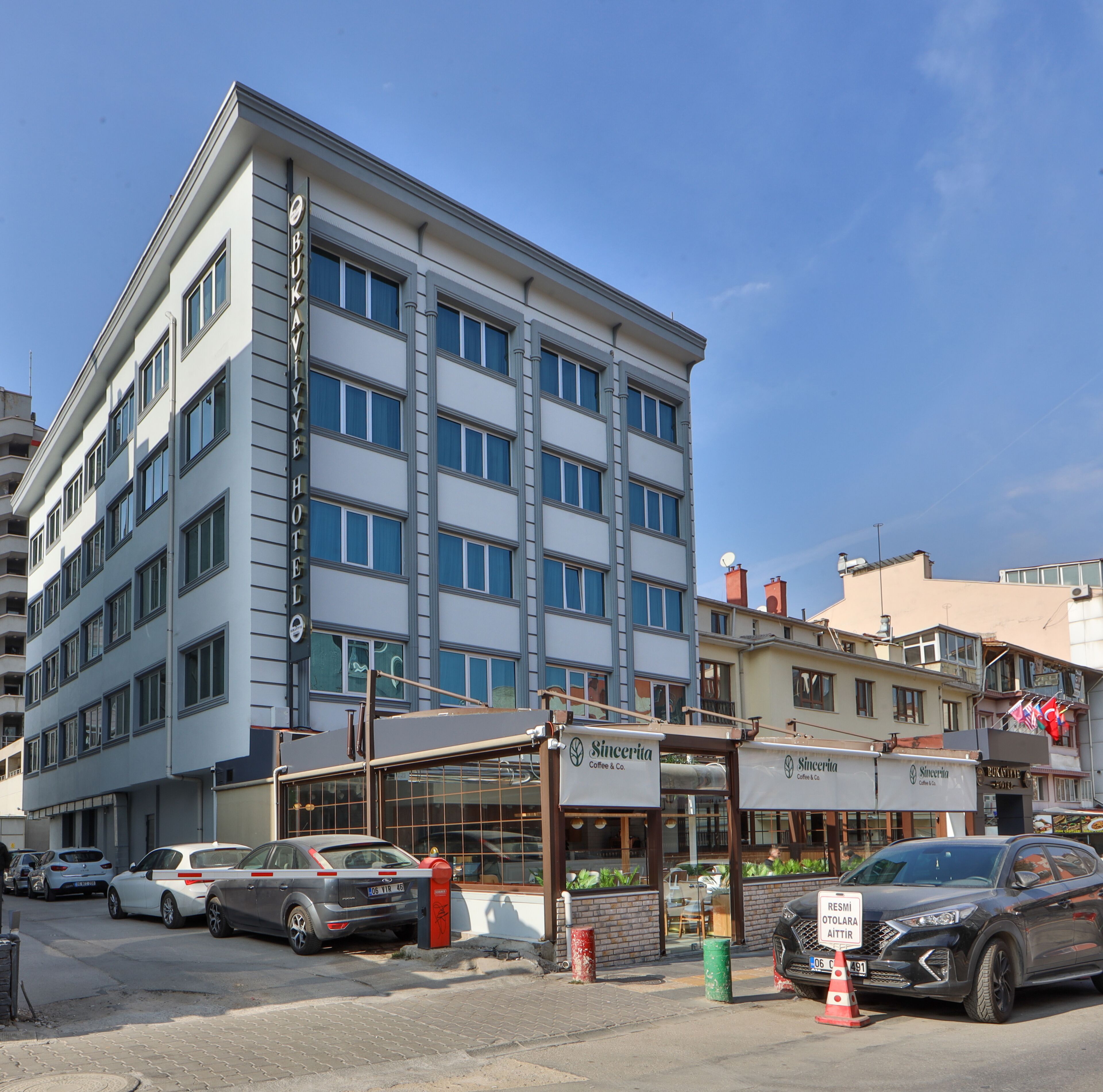 A multi-story hotel with a modern facade, multiple windows, and a visible entrance with signage.
