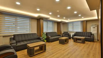 A modern living room with a sofa set, coffee table, and a potted plant.