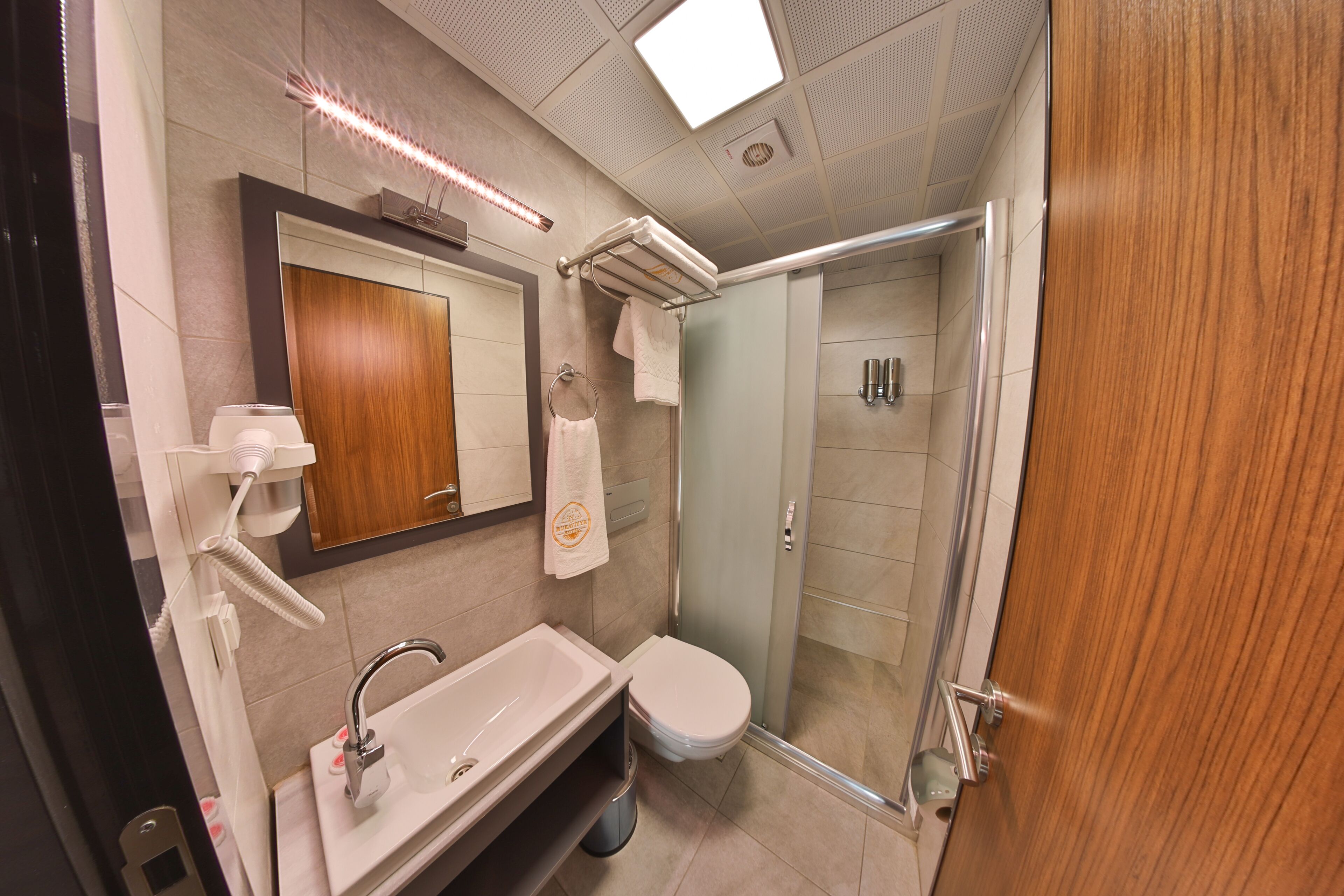 A modern bathroom with a sink, mirror, and shower.