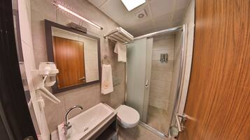 A modern bathroom with a sink, mirror, and shower.