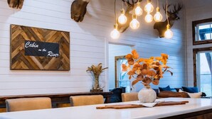 A modern kitchen with a large island, wooden wall decor, and a deer head mounted on the wall.