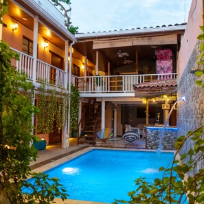 A two-story building with a swimming pool, outdoor seating, and a waterfall feature. - Hotel Casa Alma (Cartagena)
