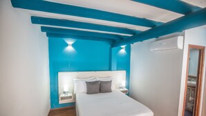 Ein Schlafzimmer mit Bett, Nachttischen und einer Klimaanlage.
