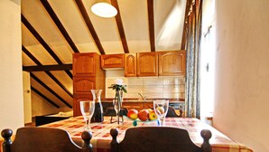 A dining table with two chairs, a vase with flowers, and a fruit bowl. - Apartments Lemes - Comfort One Bedroom Apartment With Garden View (Janjina)