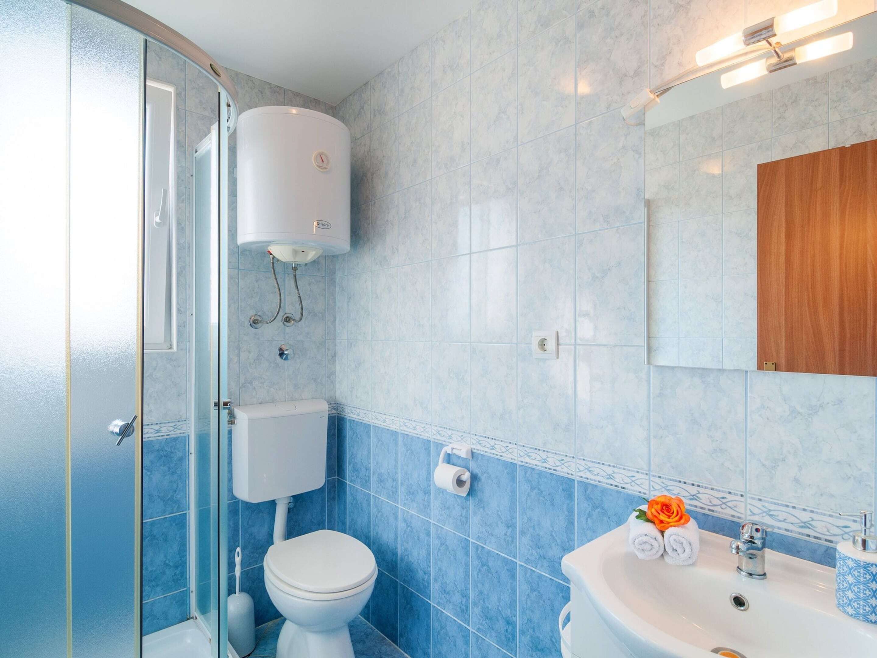 Ein Badezimmer mit Toilette, Waschbecken und Duschbereich.